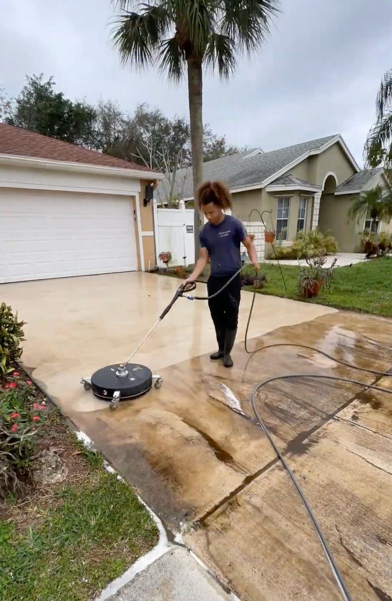 Surface cleaner attachment cleaning a residential concrete driveway in South Florida