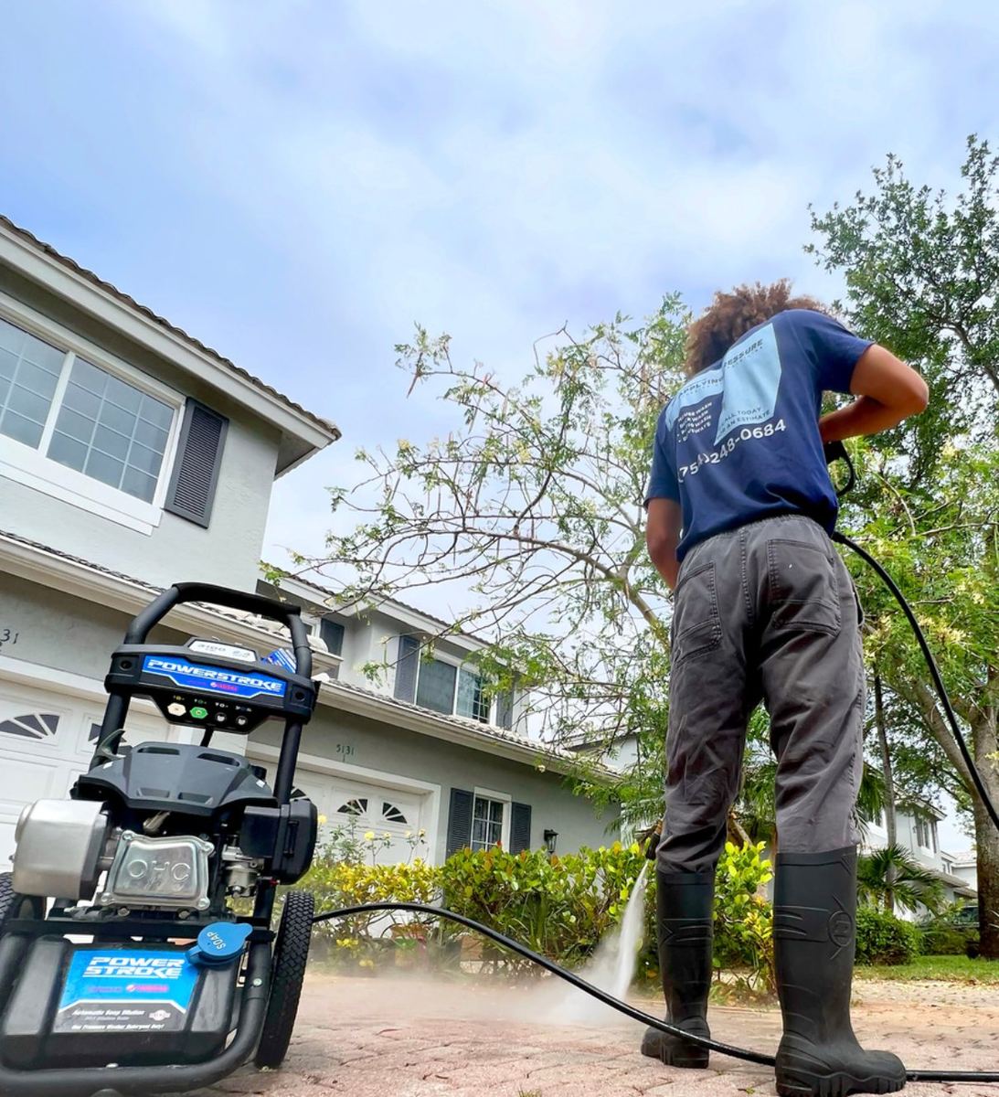 Applying Pressure technician operating a Powerstroke pressure washer outside a South Florida home
